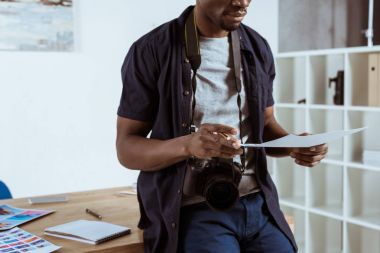 Afrika kökenli Amerikalı fotoğrafçı işyerinde elinde photoshoot örneklerle kadeh kırpılmış