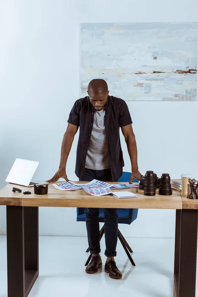 Geconcentreerde Afro Amerikaanse Fotograaf Kijken Fotoshoot Voorbeelden Terwijl Staande Werkplek — Gratis stockfoto