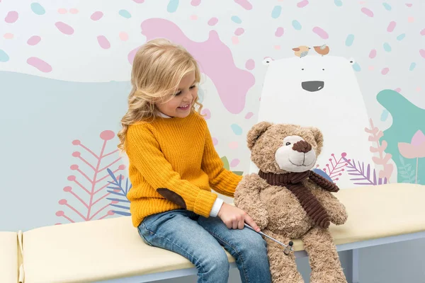 Mädchen macht neurologische Untersuchung von Teddybär — Stockfoto