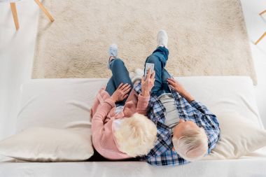 kanepede televizyon izlerken uzaktan kumanda ile üst düzey çiftin Üstten Görünüm