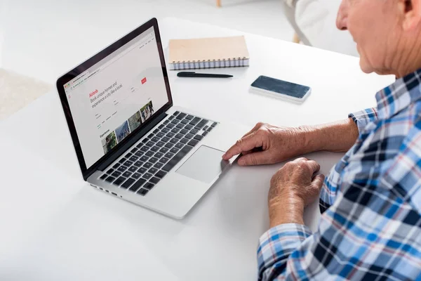 Partial View Senior Man Sitting Table Using Laptop Airbnb Logo — Stock Photo, Image