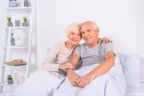 Portrait Smiling Senior Couple Resting Bed Looking Camera Home — Stock Photo, Image