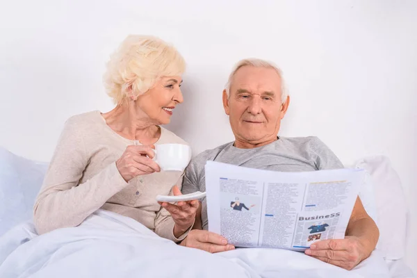 Portrait Senior Woman Drinking Coffee While Husband Reading Newspaper Bed — Stock Photo, Image