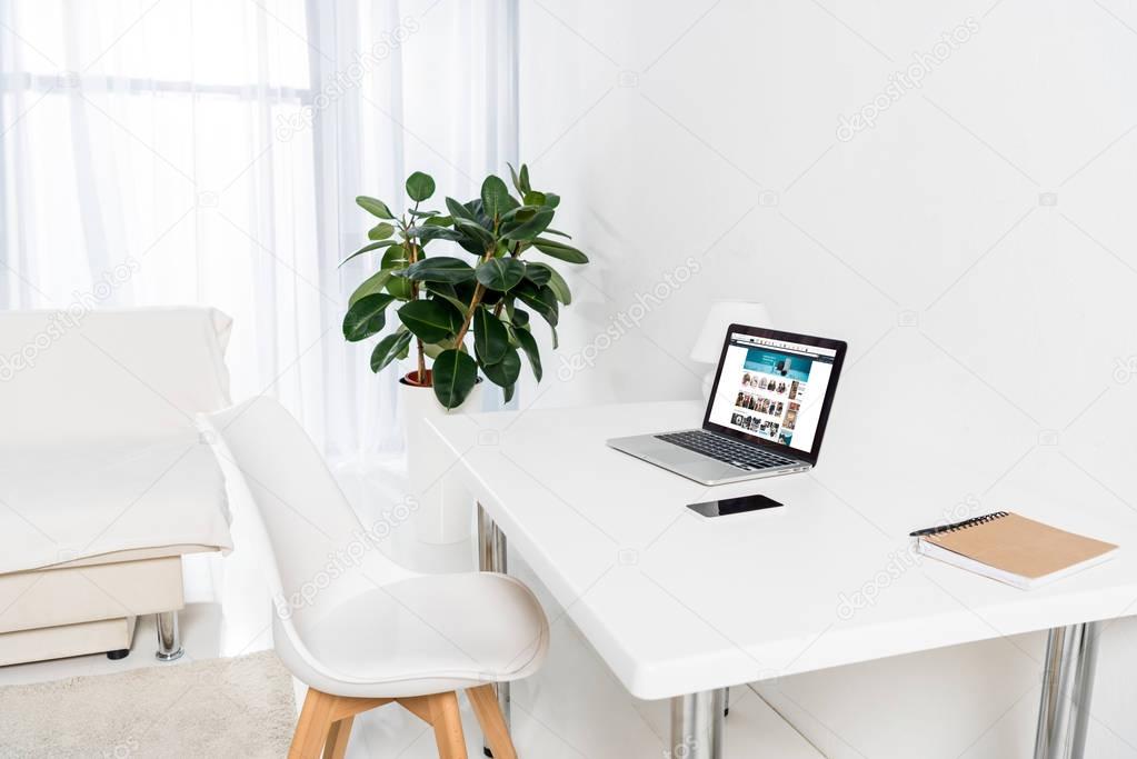 Home office with laptop, smartphone and notebook on table