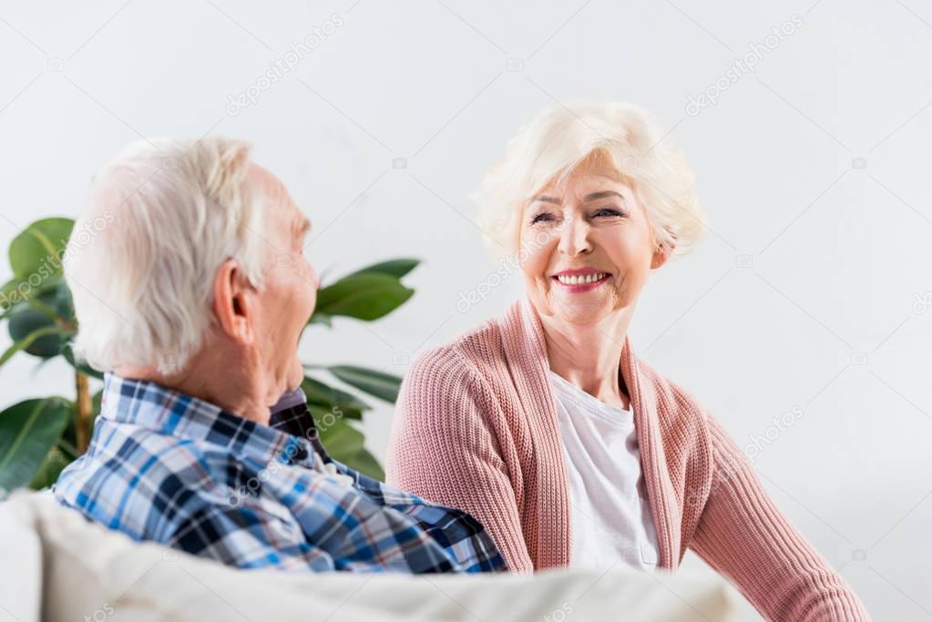 beautiful senior couple sitting on couch at home and talking