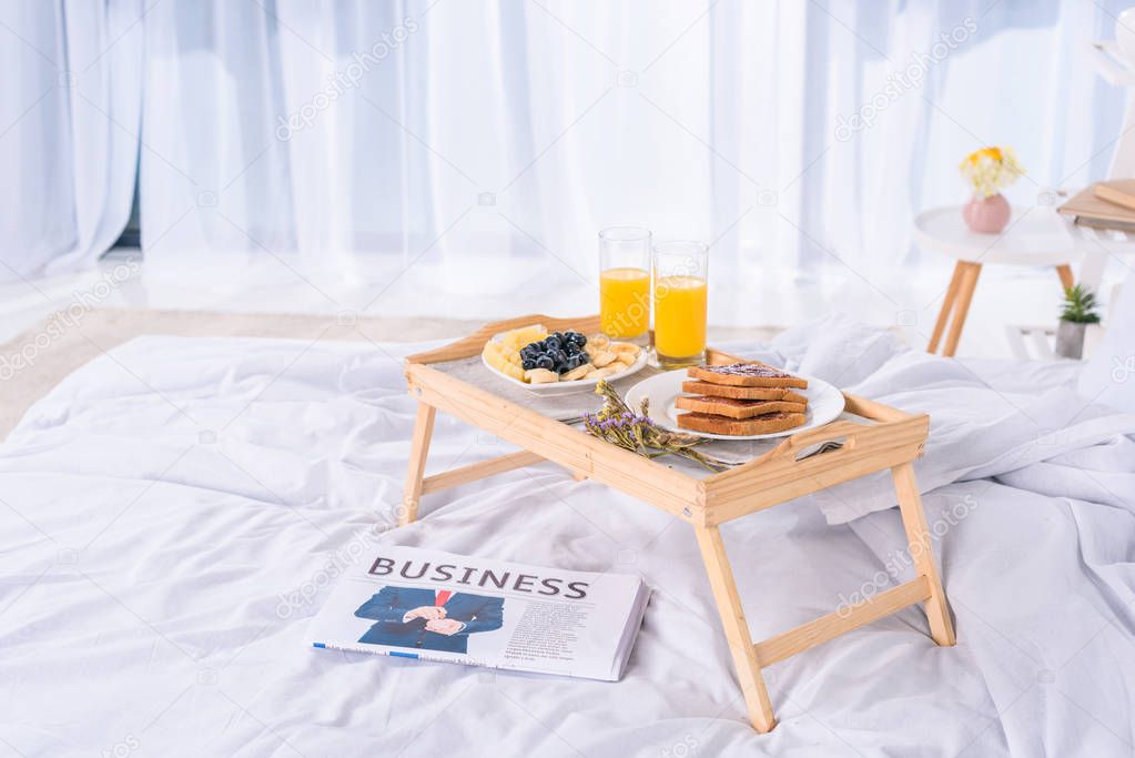 healthy breakfast in bed on wooden tray at morning