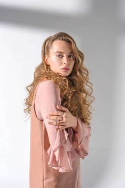 Kendine güvenen kız ayakta ve moda çekimi için poz kıvırcık saçlı