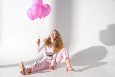 smiling girl with bundle of pink balloons sitting and looking up clipart