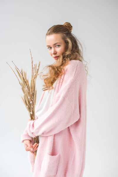 веселая девушка стоит и держит кучу ивовых ветвей дерева изолированы на белом
 