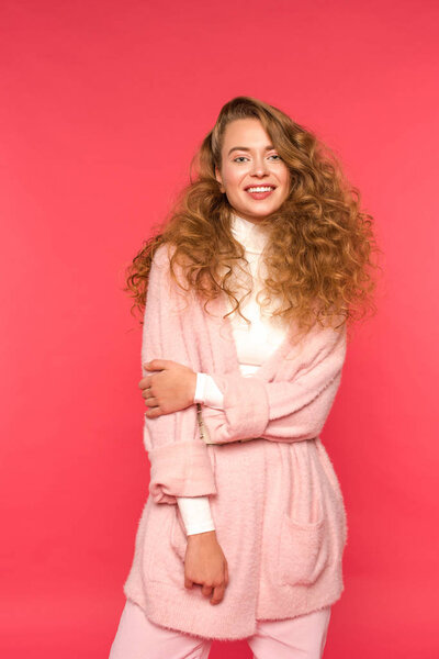 улыбающаяся женщина в теплой одежде, смотрящая на камеру, изолированную на красный
