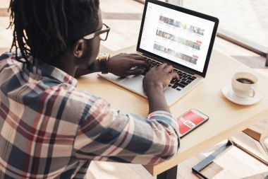 Afrika kökenli Amerikalı adam laptop ve smartphone ile youtube parçalar