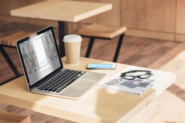 LinkedIn Web sitesi, skype ve iş gazete kafede masada ile smartphone ile dizüstü bilgisayar