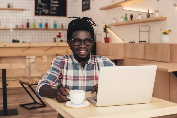 Усміхнений Афроамериканський Чоловік Кавою Ноутбуком Кафе — стокове фото