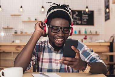 müzik dinleme ve kahve dükkanında smartphone kullanarak Afrika kökenli Amerikalı adam