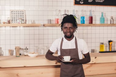 Afro-Amerikan barista kahve fincanı bar sayacı, dururken tutan önlük