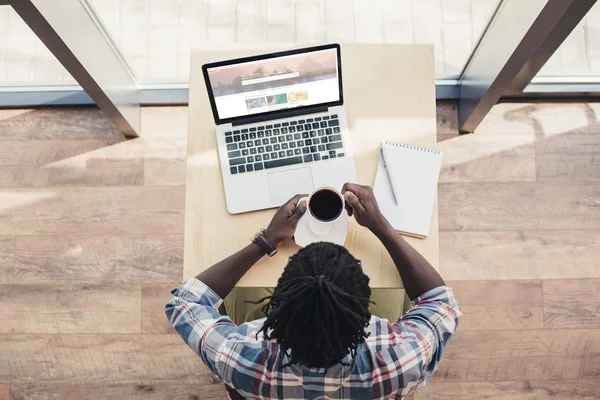 커피를 마시고 Shutterstock 웹사이트와 노트북을 아프리카계 미국인 남자의 — 스톡 사진