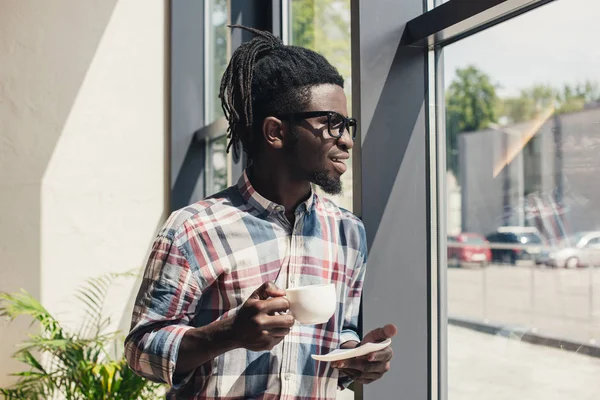 African American Man Picia Kawy Stojąc Przy Oknie — Zdjęcie stockowe