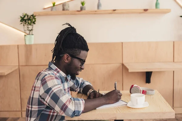 Afro Amerikaanse Man Schrijven Kladblok Tijdens Koffiepauze Café — Gratis stockfoto