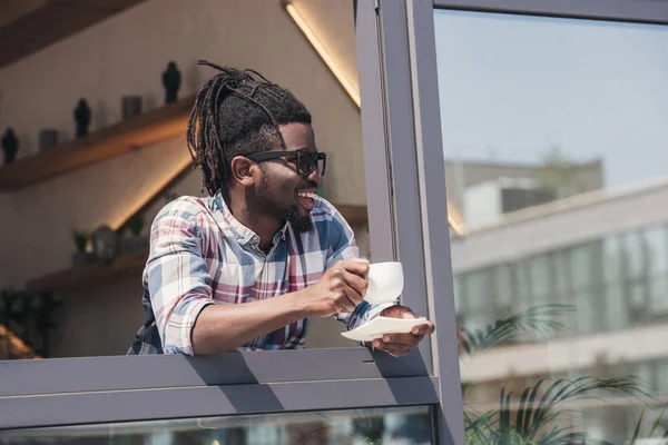 カフェでコーヒーを飲みながら陽気なアフリカ系アメリカ人 — ストック写真