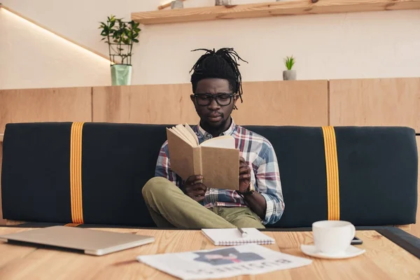 Afro Amerikaanse Man Lezen Boek Zittend Bank Café — Stockfoto