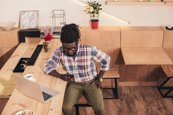 Афроамериканський Чоловік Використовує Ноутбук Смартфон Барній Стійці Кафе — Безкоштовне стокове фото