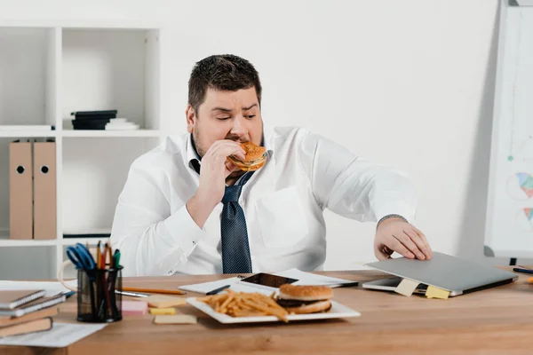 Overweight Businessman Eating Hamburger Using Laptop Office — Stock Photo, Image