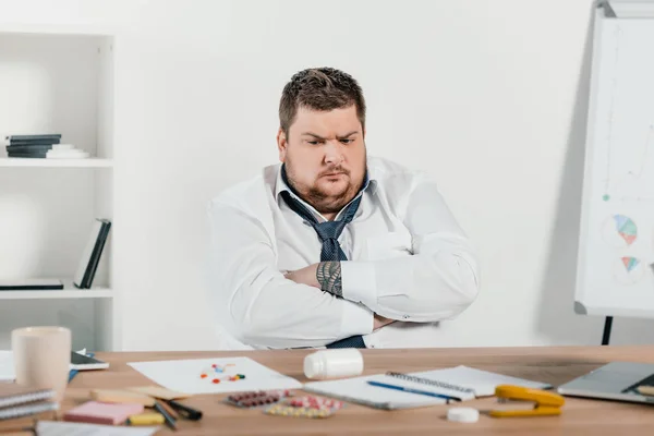 Übergewichtiger Geschäftsmann Sitzt Arbeitsplatz Und Schaut Sich Pillen — Stockfoto