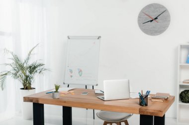 Beyaz tahta ve saat ofiste işyeri dizüstü bilgisayar ve ofis malzemeleri