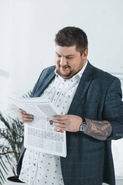 ofiste gazetede takım elbiseli şişko işadamı