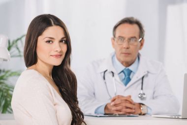 çekici kadın hasta oturma kliniğinde ve kameraya bakıyor