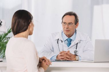 male doctor and female patient sitting at talking at clinic