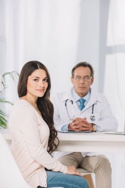 güzel kadın hasta oturma kliniğinde ve kameraya bakıyor