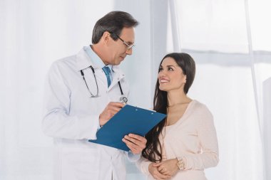 smiling doctor and patient looking at each other clipart