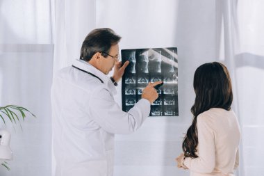 Doktor kadın hasta x-ışını fotoğrafı işaret