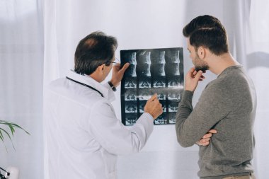 Doktor erkek hasta x-ışını fotoğrafı işaret