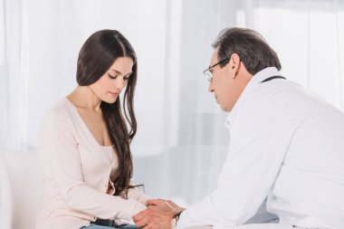 erkek doktor üzgün kadın hasta tutuşup