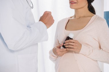 hapları tutarak ve dinleme doktor hamile kadının kırpılmış görüntü