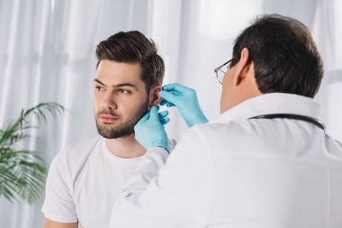 doctor examining male patient ear clipart