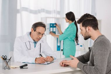 erkek hasta doktor kliniğinde konuşuyor