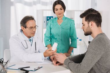 yakışıklı delikanlı hapları vermeye doktor