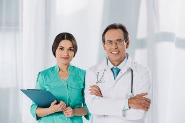 mutlu hemşire ve doktor ayakta ve kameraya bakıyor