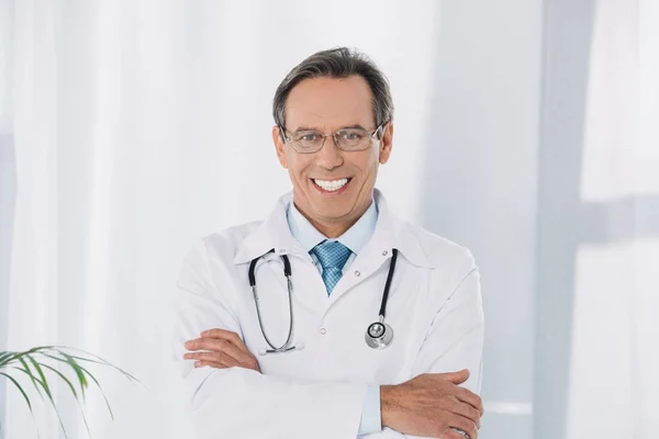 Médico Sorrindo Com Mãos Cruzadas Olhando Para Câmera — Fotografia de Stock