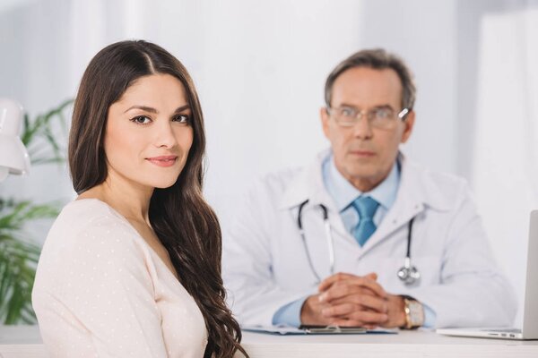 attractive female patient sitting at clinic and looking at camera