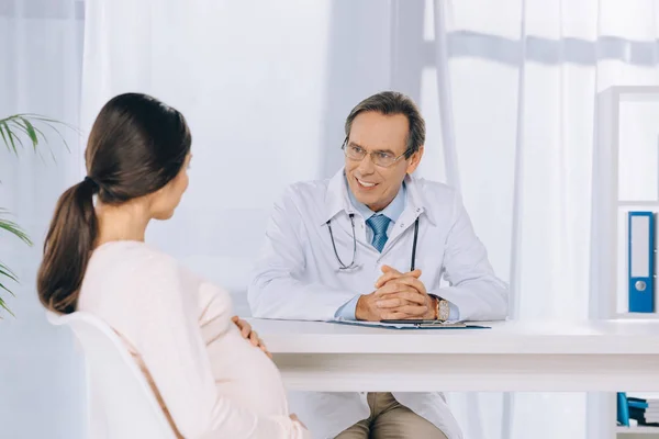 Médico Sonriente Escuchando Mujer Embarazada Clínica — Foto de Stock