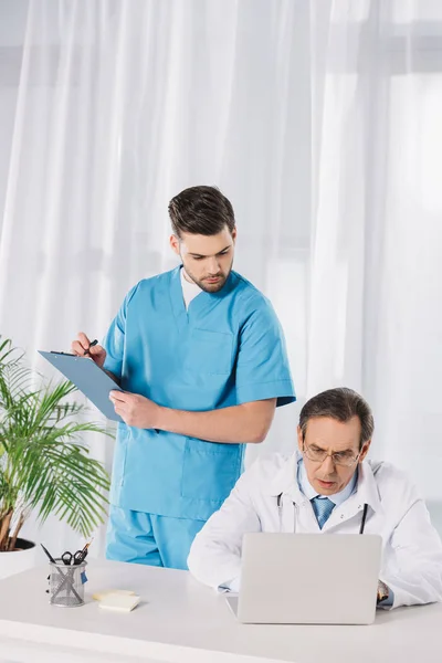 护士和医生看工作笔记本电脑 — 图库照片