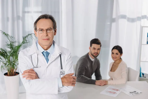 Dokter Permanent Met Gekruiste Handen Voorgrond — Stockfoto