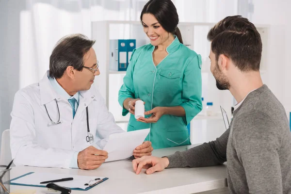 Lächelnde Krankenschwester Zeigt Dem Arzt Tabletten — Stockfoto