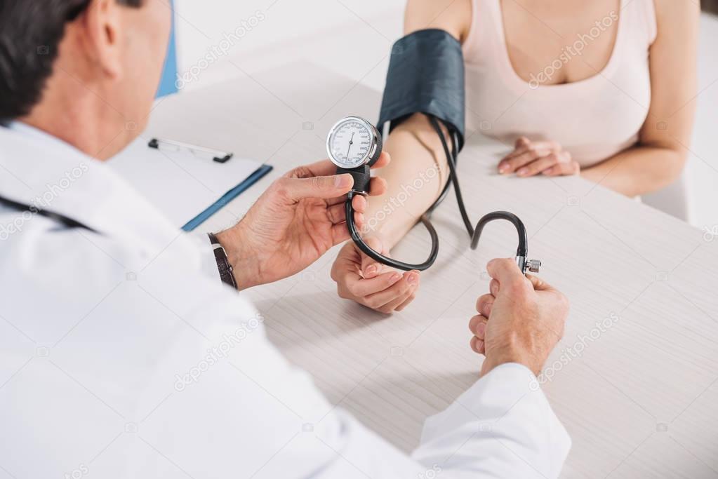 cropped image of doctor measuring patient pressure 