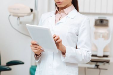 Klinikte elinde dijital tablet kullanarak optometrist kırpılmış atış