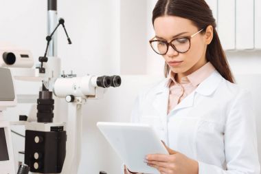 Klinikte dijital tablet kullanarak odaklı optometrist portresi